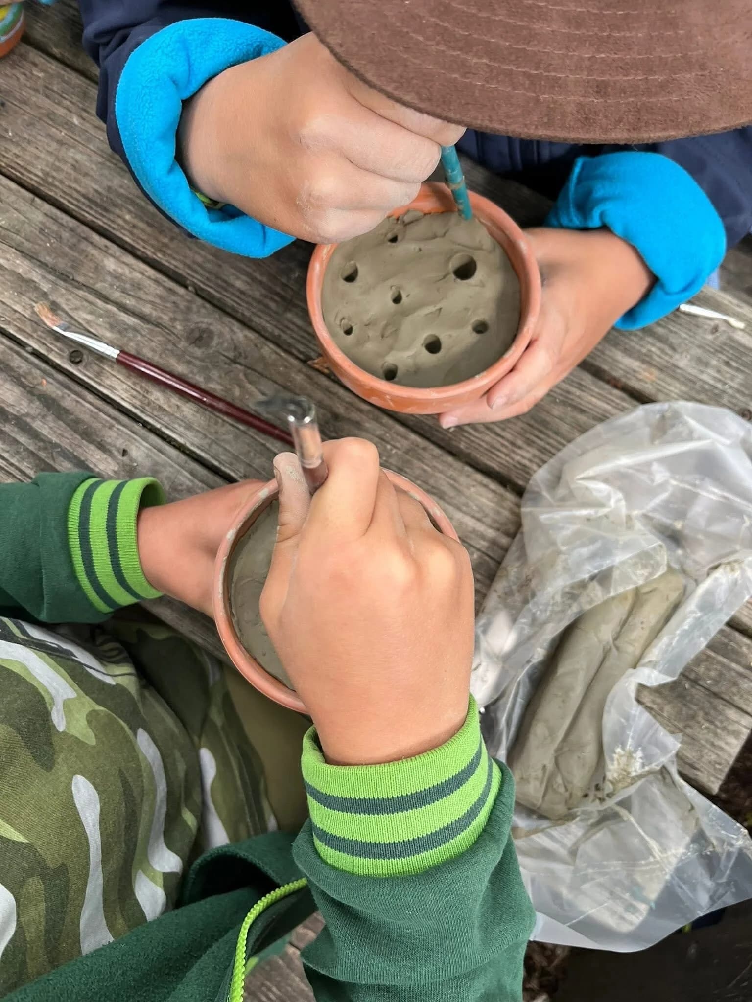 Kinderhände gestalten Ton in kleinen Schalen
